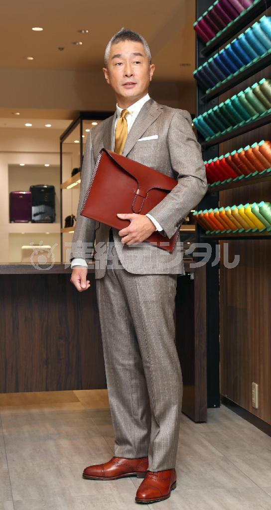 「アトリエメイド」による「４５歳部長職」をイメージしたコーディネート。茶色がかったスーツ（松屋オリジナル、７万６０００円）にラウンドカラーのシャツ（ジェニーノ、１万２０００円）、光沢のあるシルクシャンタンのネクタイ（インプロヴィゼーション、１万円）には襟元にビンテージのカラークリップ（４０００円）をつけておしゃれ感をアップ。ポケットチーフ（フェアファクス、４０００円）は清潔感のある白。クラッチバッグ（Ｒｕｔｈｅｒｆｏｒｄｓ、４万円）と革靴（グレンソン、６万８０００円）は色をあわせて引き締めた印象に＝２０１５年８月３１日、東京都中央区銀座の松屋銀座（野村成次撮影）
