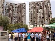 大規模爆発発生から１２日後の８月２５日、天津市の窓ガラスなどが破壊された高層マンションの前には、地方政府の幹部らに抗議するため、住民らが集まった＝２０１５年、中国（共同）