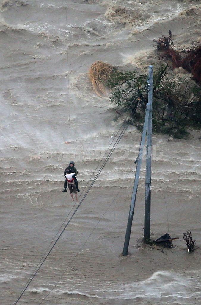 濁流の中、電柱にしがみついていた男性を救助する自衛隊員＝２０１５年９月１０日午後、茨城県常総市（本社チャーターヘリから、大山文兄撮影）
