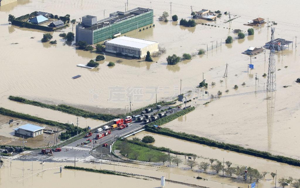 大規模な水害に見舞われ、９月１１日朝を迎えた茨城県常総市で、冠水した道路を避けて駐車する消防や自衛隊の車両＝２０１５年（共同通信社ヘリから撮影）
