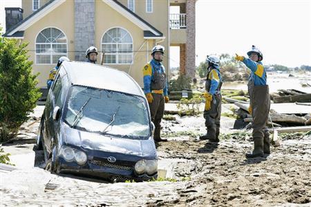 決壊した鬼怒川の堤防の周辺で行方不明者を捜索する警察官＝２０１５年９月１１日、茨城県常総市（共同）