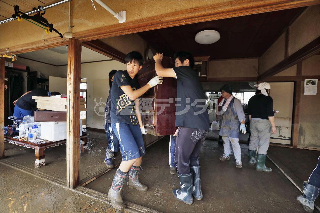 床上浸水した住宅から家具を運び出す地元の高校生＝２０１５年９月１２日、茨城県常総市（共同）