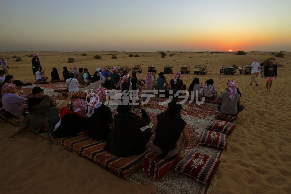 砂丘を越えたところで一休み。海岸線に沈む夕日をしばし鑑賞する＝２０１４年１１月２７日、アラブ首長国連邦・ドバイ（倉谷清文さん撮影）