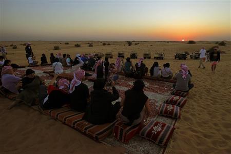 砂丘を越えたところで一休み。海岸線に沈む夕日をしばし鑑賞する＝２０１４年１１月２７日、アラブ首長国連邦・ドバイ（倉谷清文さん撮影）