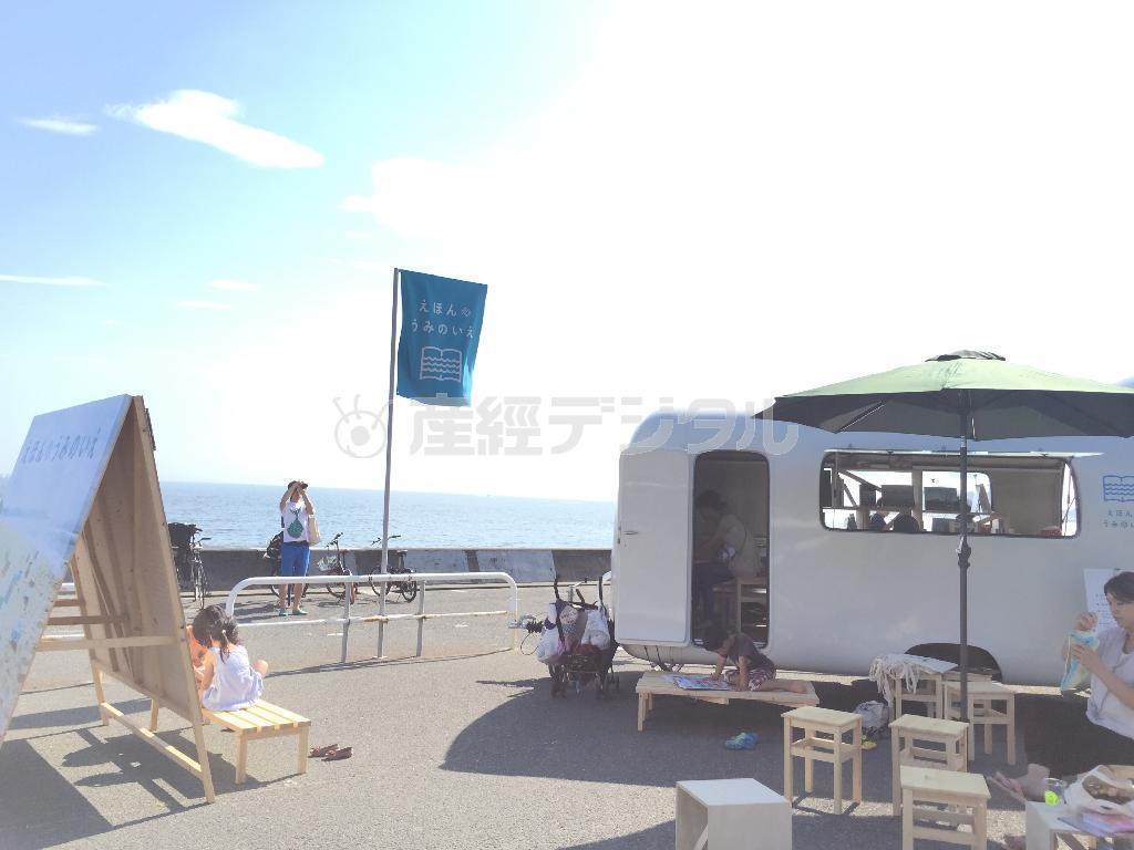 鎌倉市七里ガ浜にお目見えしたトレーラハウス「えほんのうみのいえ」で絵本を読む子供たち＝２０１５年７月２０日、神奈川県（日本財団提供）