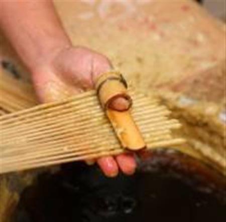 一本一本手作業で作り上げられる櫨（はぜ）ろうそく。「手掛け」という製法で均一に形を整える（大與提供）