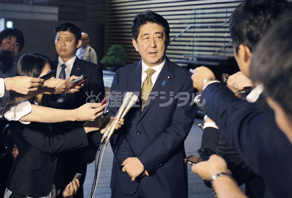 自民党総裁に無投票で再選され、記者団の質問に答える安倍晋三（しんぞう）首相（中央）＝２０１５年９月８日午前、首相官邸（共同）