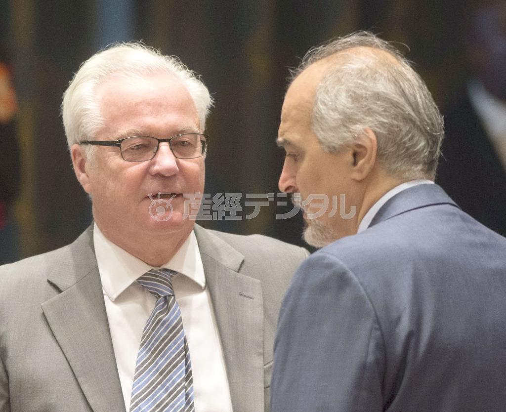 シリアのバシャール・ジャファリ国連大使（右）と言葉を交わすロシアのヴィタリー・チュルキン国連大使。ロシアの軍事支援強化が米露関係の緊張を高めている＝２０１５年８月７日、米ニューヨーク、国連安全保障理事会の議場（国連提供・共同）