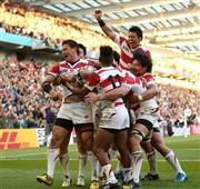 後半、トライを決めた五郎丸歩（ごろうまる・あゆむ、左）に駆け寄るフィフティーン＝２０１５年９月１９日、英イースト・サセックス州ブライトン（山田俊介撮影）