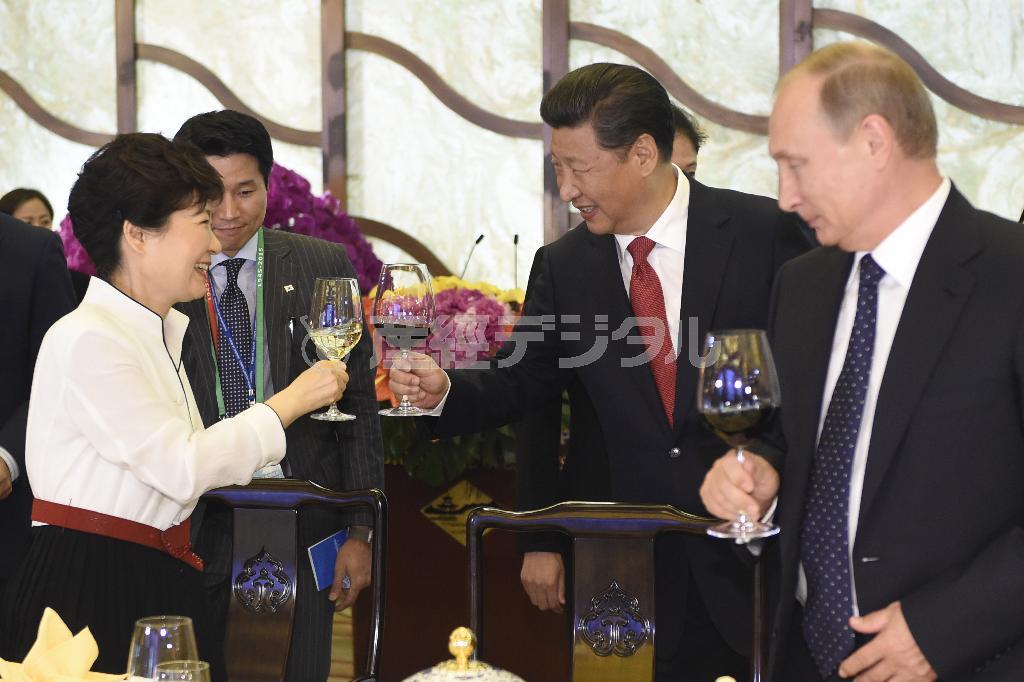 軍事パレード前日の夕食会で乾杯する韓国の朴槿恵（パク・クネ）大統領（左）と中国の習近平国家主席。右はロシアのウラジーミル・プーチン大統領。果たして韓国の対中傾倒は「歴史的な提携」なのか「自滅への道」なのか＝２０１５年９月２日、中国・首都北京市の釣魚台迎賓館（共同）