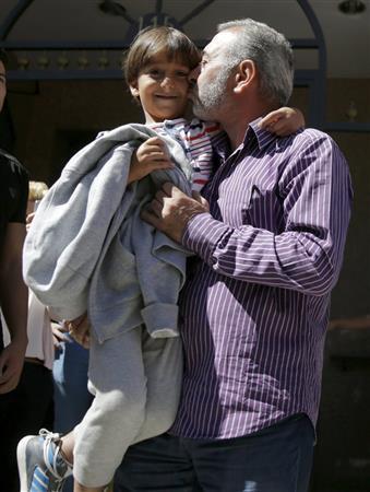 スペインに到着したザイド君は父親にキスされ、満面の笑みを浮かべた＝２０１５年９月１７日、スペイン・首都マドリード郊外のヘタフェ（ロイター）