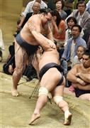 鶴竜（かくりゅう、左）は押し出しで妙義龍（みょうぎりゅう）に敗れる＝２０１５年９月２２日、東京都墨田区・両国国技館（共同）