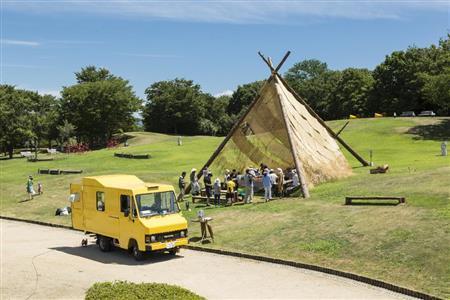 アート作品と食がコラボレーションする「潟るカフェ」。黄色いキッチンカーで、メインフィールドの４つの潟などを巡りながら（３週間ごと）、潟の食材や潟周辺地域で採れた食材を使ったメニューを土日限定（営業時間：１１～１５時）で提供する。建築家・金野千恵によるカフェの設えの中で、新潟の食を堪能する。また、カフェの設えは各潟によって形を変えていく移動アートとして楽しむことができる＝２０１５年８月９日（中村脩さん撮影、提供写真）