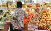 東京都内のスーパーマーケットの野菜売り場で品定めする買い物客。食品などは値上がりしており、統計と消費者の実感は異なっている