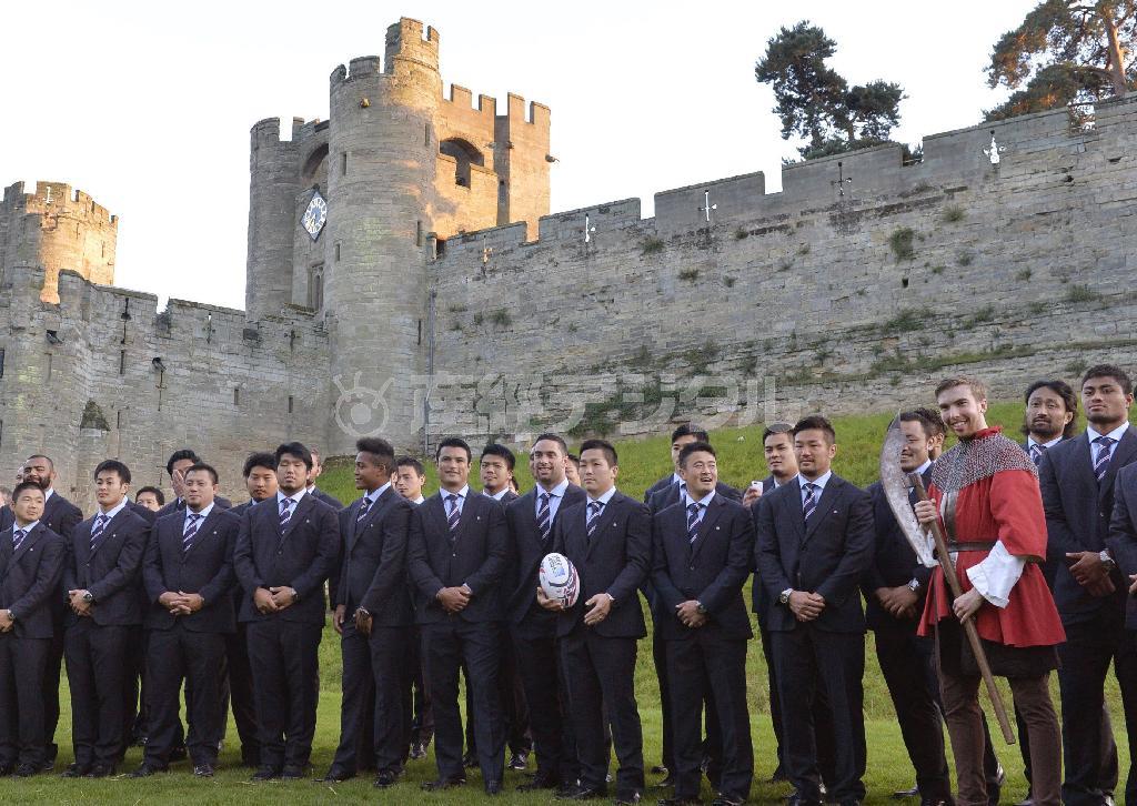 合宿地での歓迎レセプションで、ウォリック城を背景に記念撮影する（右から）アマナキ・レレイ・マフィ、大野均ら日本代表フィフティーン。後列左端はリーチ・マイケル主将＝２０１５年９月２５日、英国・ウォリック（共同）