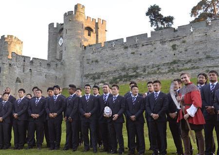 合宿地での歓迎レセプションで、ウォリック城を背景に記念撮影する（右から）アマナキ・レレイ・マフィ、大野均ら日本代表フィフティーン。後列左端はリーチ・マイケル主将＝２０１５年９月２５日、英国・ウォリック（共同）