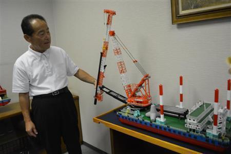 船舶用クレーンの模型を示しながら、自社の強みについて語るＳＫＫの代表取締役、牛窓正剛さん＝２０１５（平成２７）年８月２５日、高知県高知市（慶応大学、島村成撮影）