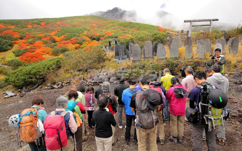 御嶽山（おんたけさん）の標高２４８０メートル付近の女人堂で、噴火の時間に合わせて山頂に向かって黙祷（もくとう）する登山者ら＝２０１５年９月２７日午前１１時５２分、長野県木曽郡木曽町（早坂洋祐撮影）
