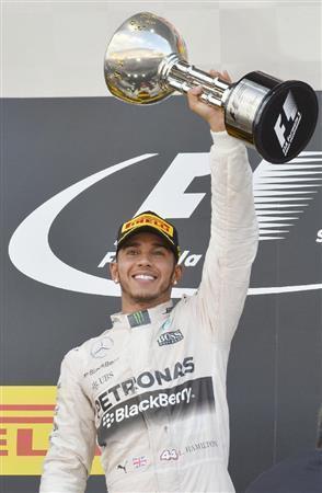 Ｆ１日本ＧＰで優勝し、表彰台でトロフィーを掲げるメルセデスのルイス・ハミルトン＝２０１５年９月２７日、三重県鈴鹿市の鈴鹿サーキット（共同）