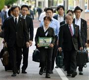 市川大輔さんの写真を手に東京地裁に入る市川正子さん（中央）と弁護士ら＝２９日午前、東京都千代田区（大西史朗撮影）