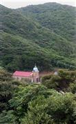自然に覆われ、ひっそりとたたずむ頭ケ島天主堂。世界遺産登録申請後、観光客が３割ほど増えているという＝２０１５年７月２１日、長崎県南松浦郡新上五島町（鈴木健児撮影）