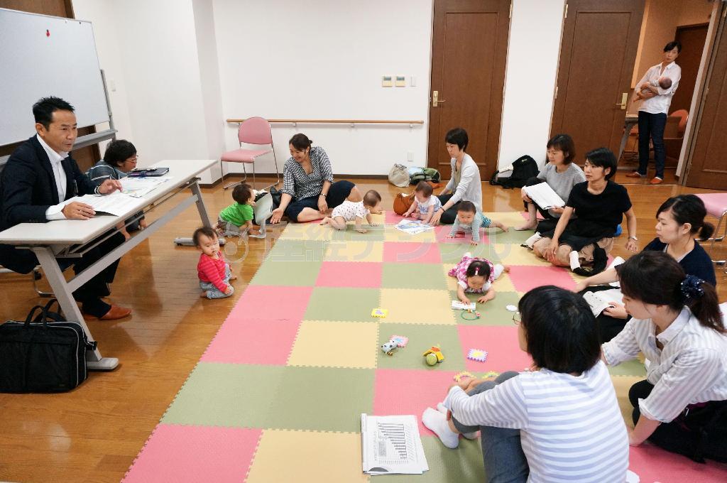 世田谷区の担当課長（左）から保育所の整備状況を聞く育児休業中の母親ら＝２０１５年９月８日、東京都世田谷区（共同）