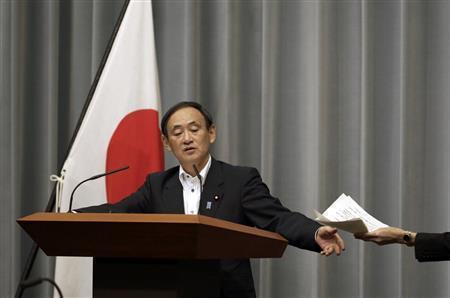 会見中にメモを受け取る菅義偉（すが・よしひで）官房長官。スパイ行為については「絶対ない」と否定した＝２０１５年９月３０日、首相官邸（ＡＰ）