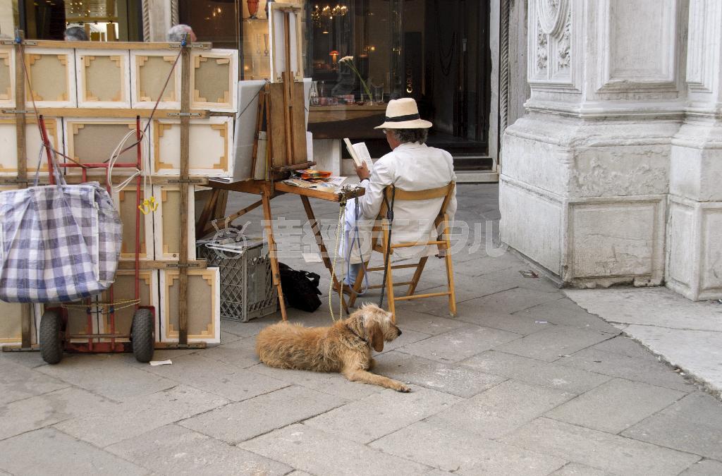 後ろ姿もおしゃれなサン・バルナバ広場の絵画屋さん。愛犬がいつも一緒だ＝イタリア・ヴェネト州ベネチア（酒井久美子さん撮影）