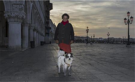 まだ夜が明けきらないサン・マルコ広場で。愛犬「ヨハネ」との散歩を楽しむ赤い服が印象的な婦人＝イタリア・ヴェネト州ベネチア（酒井久美子さん撮影）