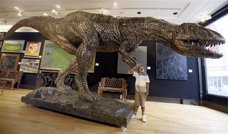 首都ロンドンのギャラリーで、恐竜時代最末期の肉食恐竜、ティラノサウルスの模型に触れて戯れる男児。ティラノサウルスは、約３００万年間、生態系の頂点に君臨したが、小惑星の地球衝突を機に姿を消していった＝２０１５年８月３日、英国（ＡＰ）