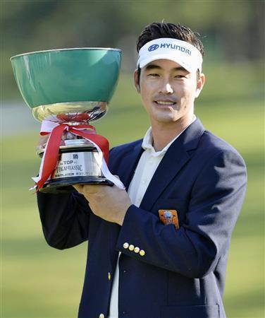 プレーオフを制し今季初優勝、カップを手に笑顔を見せる金亨成＝２０１５年１０月４日、愛知県みよし市の三好ＣＣ（共同）