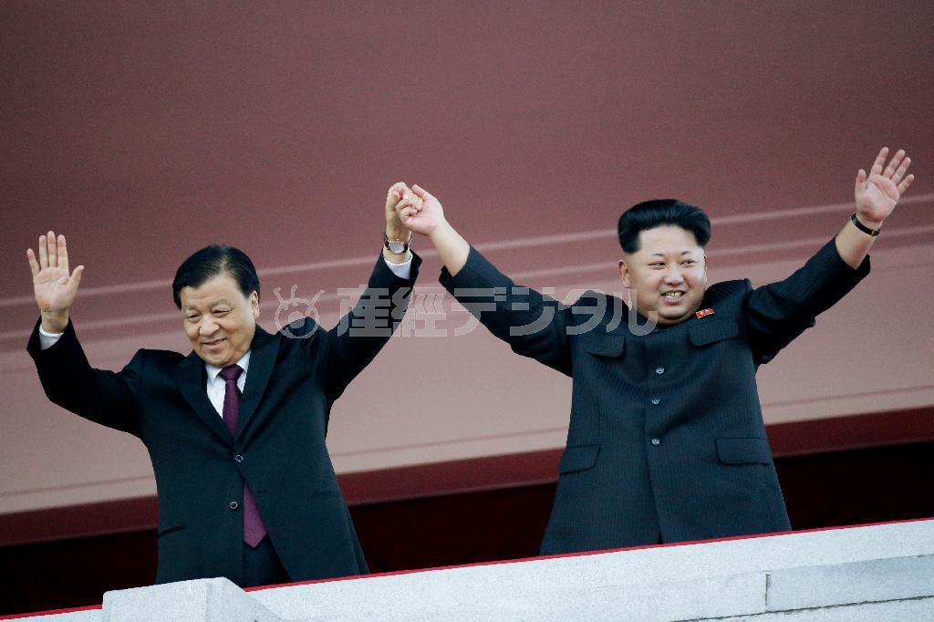 軍事パレード式典に出席し手を振る北朝鮮の金正恩第１書記（右）と中国共産党の劉雲山政治局常務委員＝２０１５年１０月１０日、北朝鮮・首都平壌市（ＡＰ）
