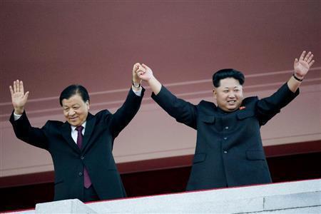 軍事パレード式典に出席し手を振る北朝鮮の金正恩第１書記（右）と中国共産党の劉雲山政治局常務委員＝２０１５年１０月１０日、北朝鮮・首都平壌市（ＡＰ）