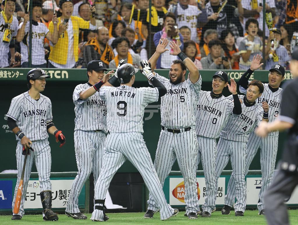 一回、ソロ本塁打を放ったマット・マートン（９）を出迎えるマウロ・ゴメス（中央）ら阪神ナイン＝２０１５年１０月１１日、東京都文京区の東京ドーム（吉沢良太撮影）