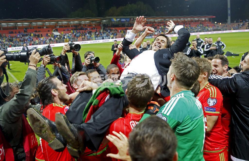 欧州選手権予選を突破し、クリス・コールマン監督を胴上げして喜ぶウェールズイレブン＝２０１５年１０月１０日（ロイター＝共同）