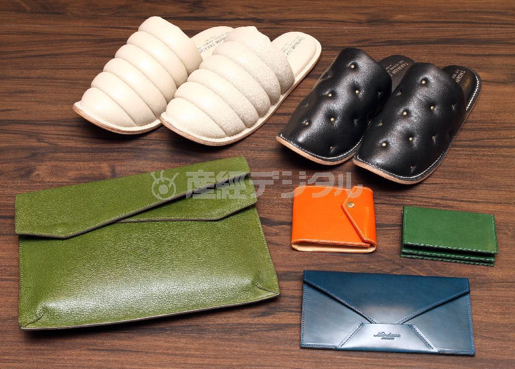 革小物も逸品ぞろい。「タキナミタカシ」のレザースリッパ（後段２点、１万９０００円）は開業医に人気の品という一生もの。「ビアベリー」のクラッチバッグ（前段左、２万４３００円）は国産豚革を使い軽くて丈夫という特徴を持つ。前段右の３点は「ムネカワ」の牛革小物。オレンジは札入れ（２万円）、緑は名刺入れ（１万５２００円）、手前の青は長財布（３万５０００円）＝２０１５年１０月５日、東京都中央区銀座（野村成次撮影）