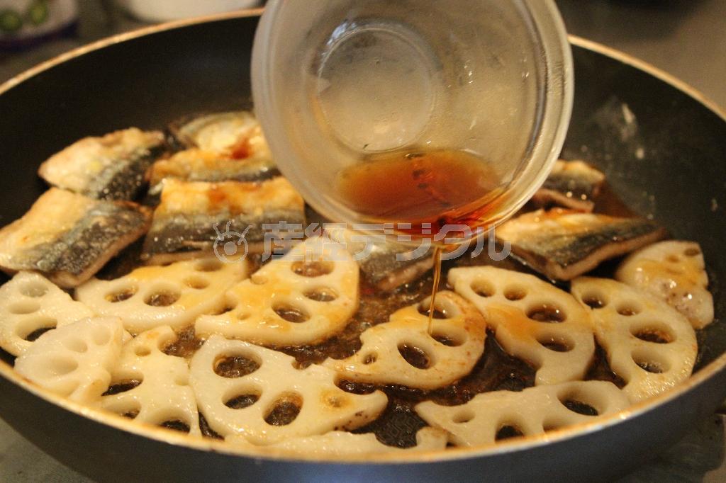 サンマとレンコンの照り焼き（作り方２）＿＿油を熱し、（作り方１：調理したサンマ）とレンコンのいずれも両面を香ばしく焼き、［合わせ調味料］を回し入れて絡める。器に盛って万能ネギを散らす。