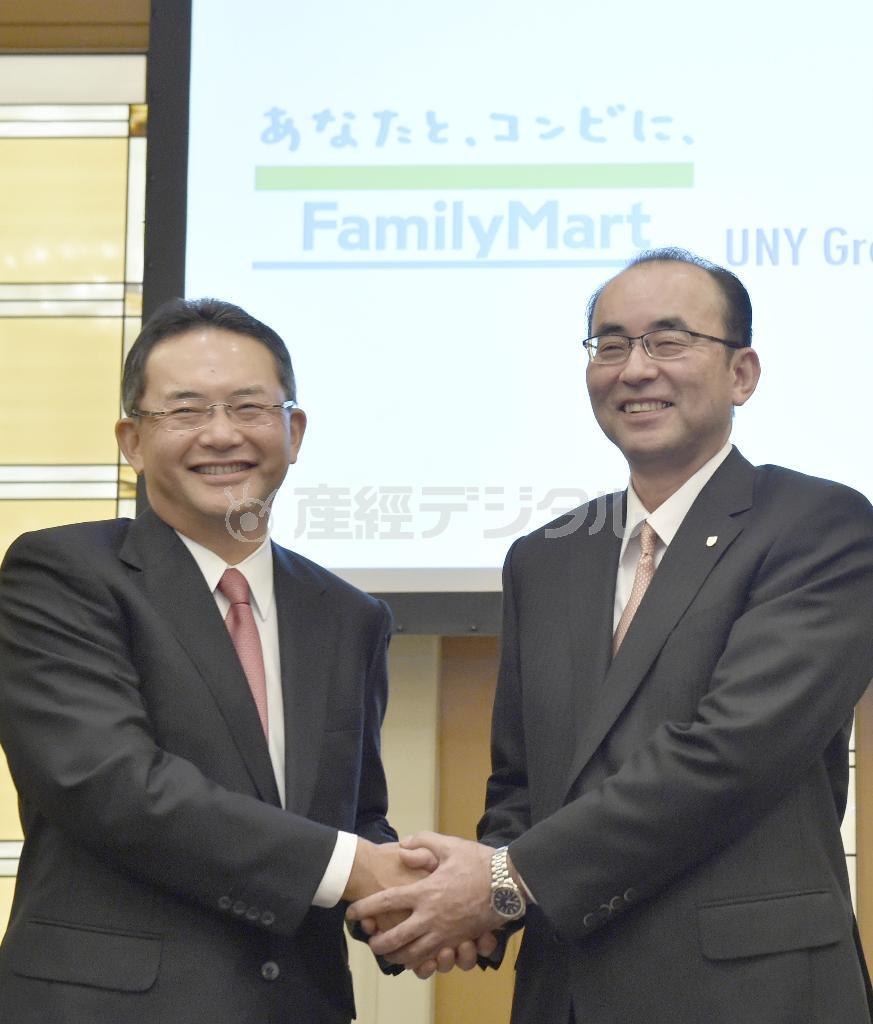 握手を交わすファミリーマートの中山勇社長（左）とユニーグループ・ホールディングスの佐古則男社長＝２０１５年１０月１５日夜、東京都内のホテル（共同）