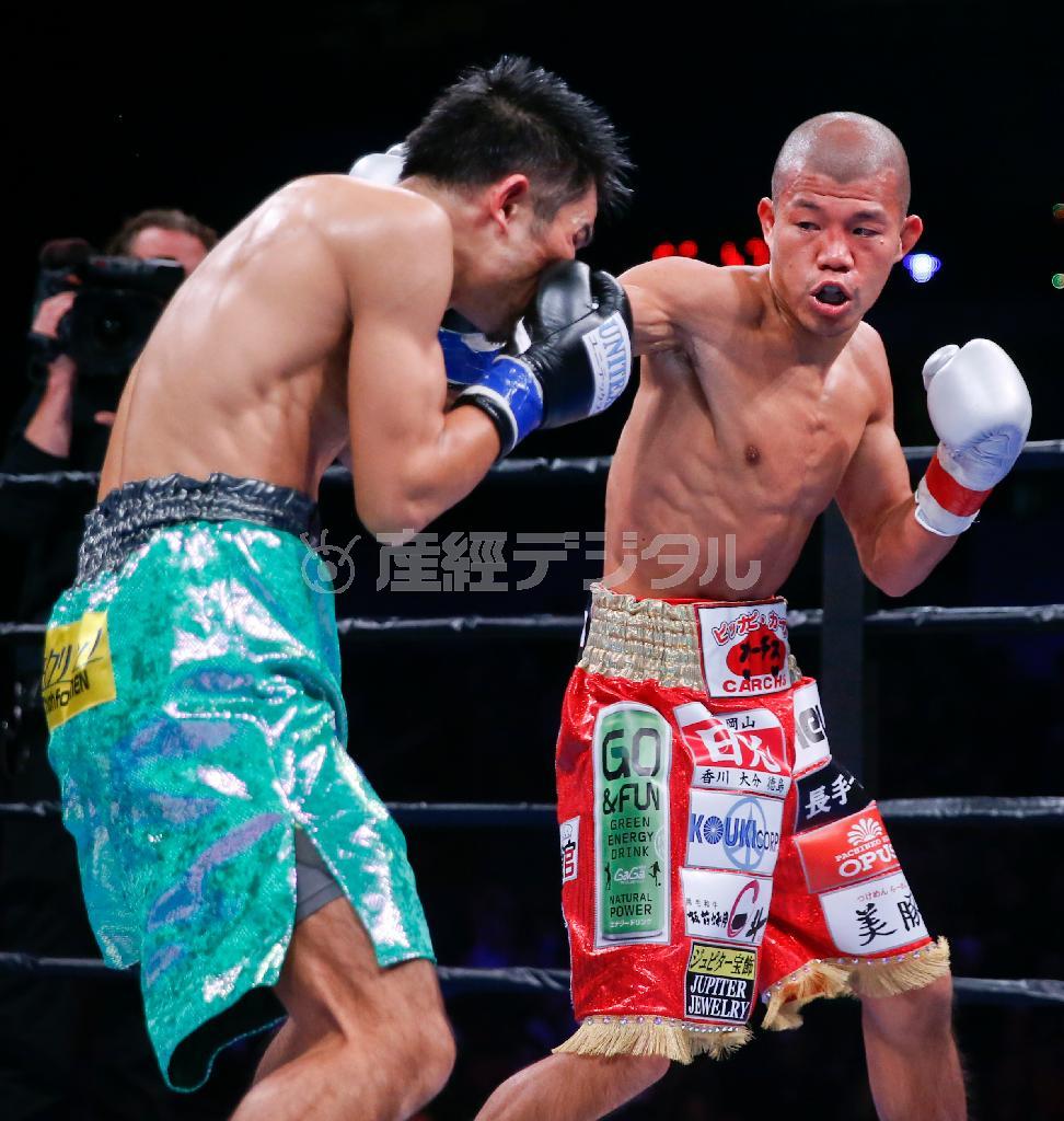 河野（こうの）公平（右）の右ボディーを浴びる亀田興毅（こうき）＝２０１５年１０月１６日、米イリノイ州シカゴ（ＡＰ）