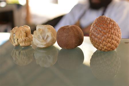 （右から）ナタンゴラの実→周りの皮を取ったもの→彫刻の途中→完成品＝２０１５年９月２３日（相川梨絵さん提供）