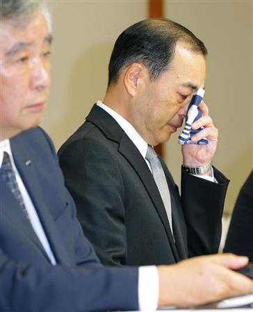 記者会見で涙を拭う旭化成の浅野敏雄社長（右）＝２０日午後、東京都千代田区