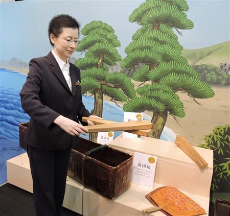 船を漕ぐ「櫓」の音を出す木を持つ、歌舞伎座ギャラリーの田野暦室長。波の音を出す「波ざる」（左下）には小豆が入っており、左右に動かして使う。雨音を出す「雨団扇」（右下）にはビーズがたこ糸で付けられ、扇ぎ方の強弱で強い雨、弱い雨と音を使い分ける＝２０１５年９月１１日、東京都中央区銀座（藤沢志穂子撮影）