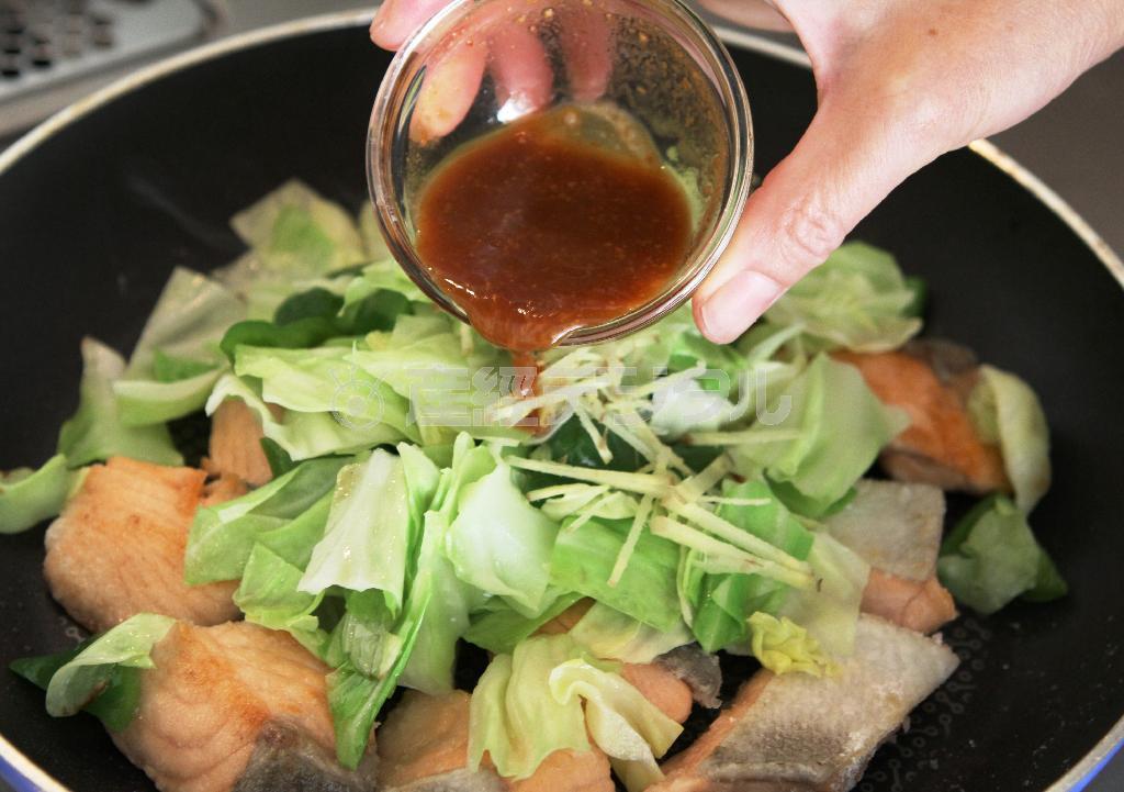 秋鮭の回鍋肉風（作り方３）＿＿フライパンをきれいにして、残りの油小さじ２を熱し、〔作り方１〕の調理したサケを皮の方から入れて両面を香ばしく焼く。中まで火が通ったら、〔作り方２：調理したキャベツやピーマン〕を戻して、しょうが、合わせておいたＡを回し入れ、全体になじむようにさっと炒める（田中幸美撮影）