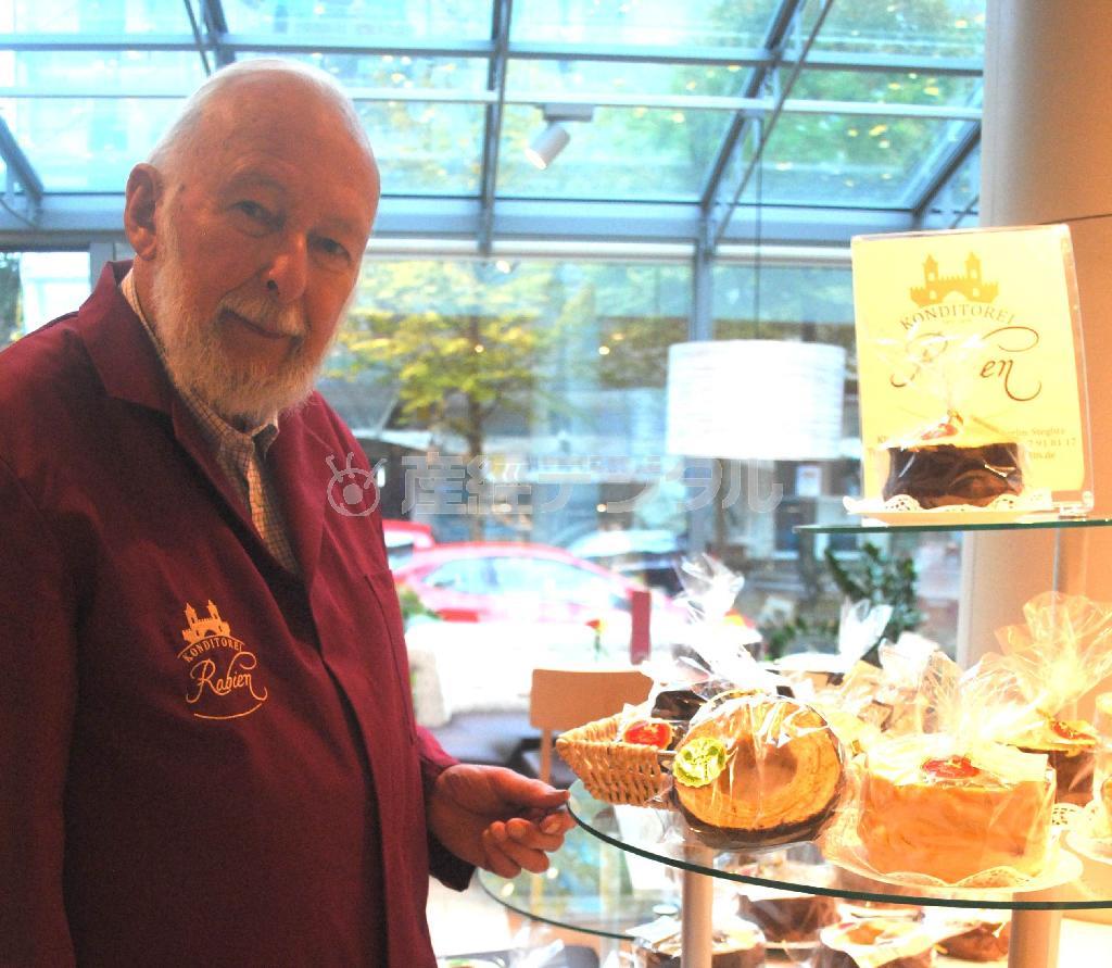 店内に陳列されたバームクーヘンと３代目店主のクラウス・ラビーンさん＝２０１５年１０月２０日、ドイツ・首都ベルリン（宮下日出男撮影）