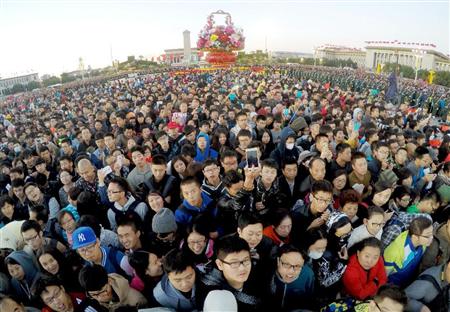 中国建国６６年の国慶節を迎え、北京の天安門広場で国旗掲揚式を見る大勢の人たち。訪日する中国人の「爆買い」は日本経済を底上げしているが、買うだけじゃなく健康志向の「診る」ことにも関心が強まっている＝１０月１日（新華社＝共同）