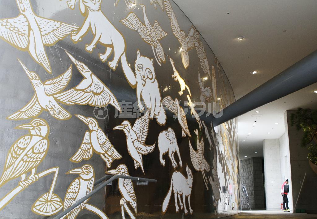 キーヤンが昨年、奇跡の星の植物館の近くの里山にいるカワセミやフクロウ、タヌキなどの生き物を描いた壁面＝２０１５年１０月１０日、兵庫県淡路市の兵庫県立淡路夢舞台温室「奇跡の星の植物館」（田中幸美撮影）