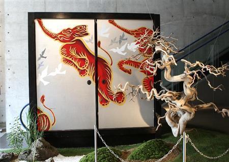 天に向かって飛ぶ襖絵の象とまるでシンクロするかのような形の真柏の盆栽。呼応し合う世界観が面白い＝２０１５年１０月１０日、兵庫県淡路市の兵庫県立淡路夢舞台温室「奇跡の星の植物館」（田中幸美撮影）