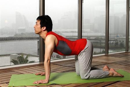 ネコのポーズ（１）。四つんばいの状態から深く息を吸い入れ、視線を天井に向けながら顎とお尻を持ち上げ腰を反らす＝２０１５年９月１７日、神奈川県横浜市神奈川区のインスパ横浜（田中幸美撮影）