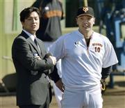 秋季練習で阿部慎之助（右）と話す巨人の高橋由伸（よしのぶ）新監督＝２０１５年１０月２８日、神奈川県川崎市多摩区のジャイアンツ球場（共同）