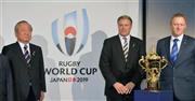 ロゴマークの前で記念撮影に応じる（左から）日本大会組織委の嶋津昭事務総長、ワールドラグビーのブレット・ゴスパー最高経営責任者（ＣＥＯ）、アラン・ギルピンＷ杯統括責任者＝２０１５年１０月２７日、英国・首都ロンドン（共同）